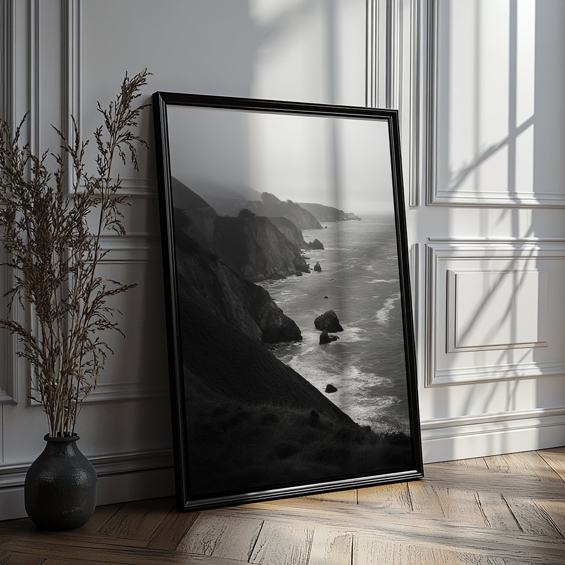 Black and white ocean landscape print featuring steep cliffs and a calm gray horizon.